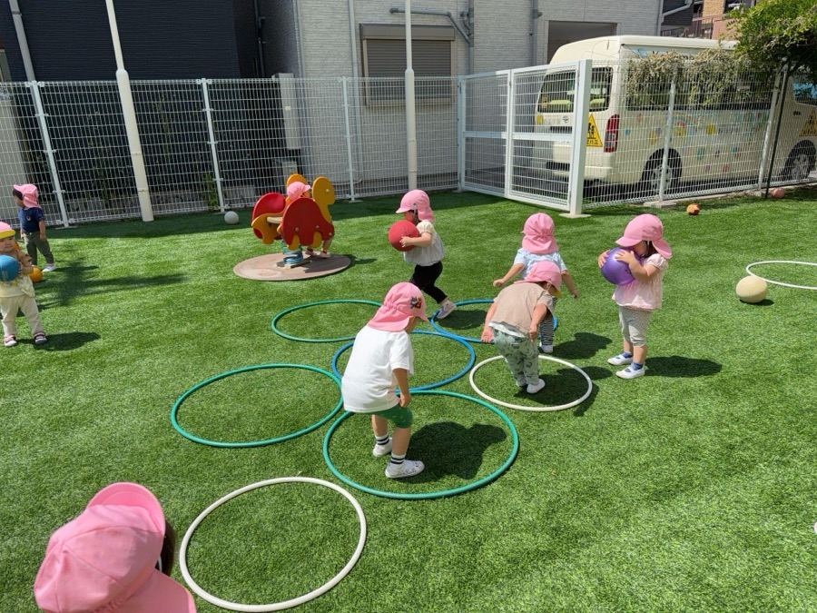 園庭でフープを使った運動あそび